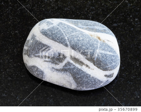 tumbled gray Gneiss stone on dark background 35670899