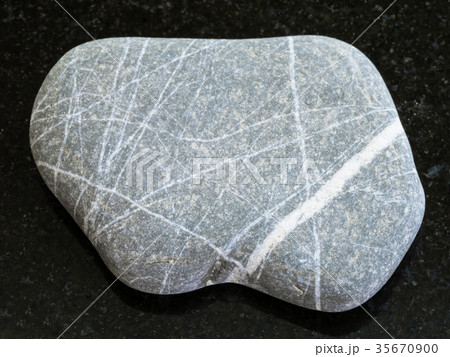 pebble of Graywacke sandstone on dark background 35670900