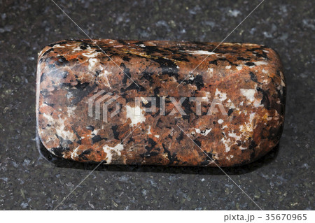 polished spreusteined urtite stone on dark 35670965