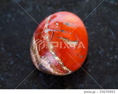 polished red Jasper gem stone on dark background 35670993