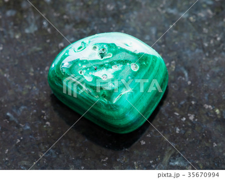 polished Malachite gemstone on dark 35670994