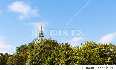 blue sky over green foliage and dome of Cathedral 35671026