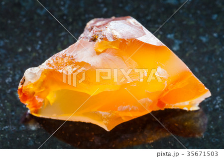raw Carnelian (chalcedony) gemstone on dark 35671503