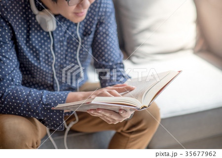 Young man university student reading book on sofa 35677962