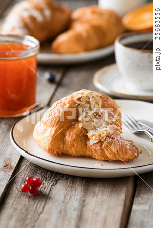 Croissant, jam and coffee on wooden table. 35683556