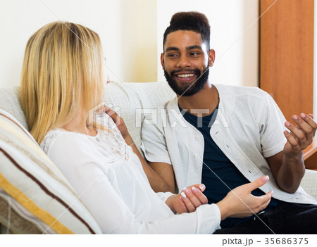Happy young people sitting indoors and talking Happy young people sitting indoors and talking 35686375
