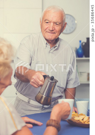 Senior man pouring coffee to female 35686445