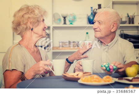 Happy senior couple enjoying conversation over cup of coffee 35686567