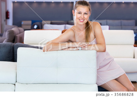 Adult female touching sofa in the furniture store before the buying Adult female touching sofa in the furniture store before the buying 35686828