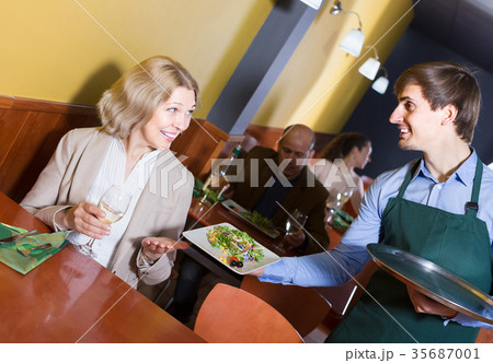 Portrait of waiter and mature woman having dinner Portrait of waiter and mature woman having dinner 35687001