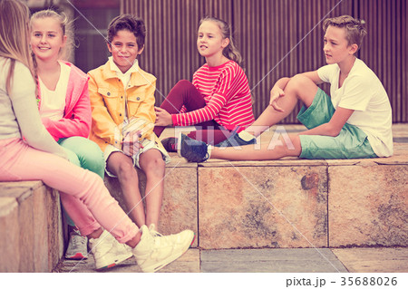 Two boys and three girls are talking about play on walk 35688026