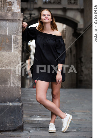 Positive young girl standing near the stone wall Positive young girl standing near the stone wall 35688416