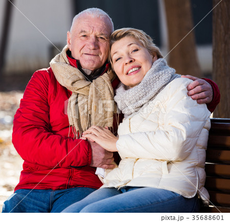 Mature couple sitting in park Mature couple sitting in park 35688601