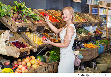 Portrait of woman buying fresh greens and fruits 35688742