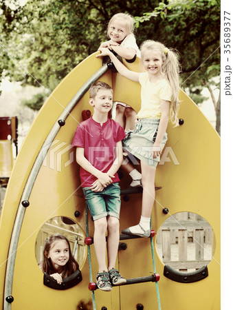Kids climbing together on playground's construction 35689377