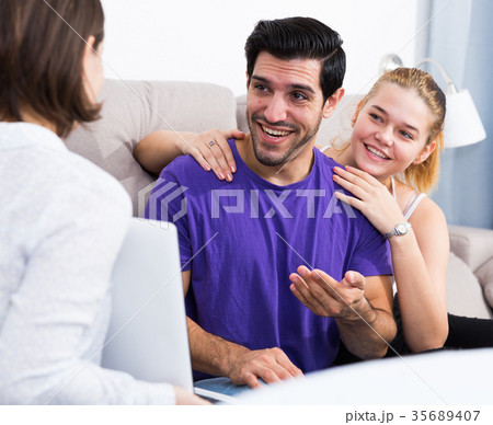 Loving couple with female designer at home 35689407