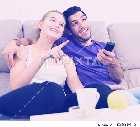 Loving couple on sofa watching TV Loving couple on sofa watching TV 35689445