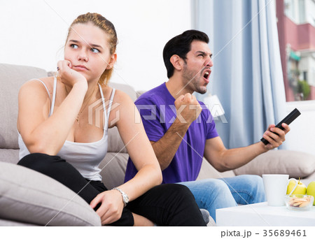 Man watching tv ignoring frustrated girl Man watching tv ignoring frustrated girl 35689461