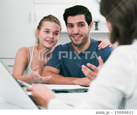 Loving couple with female designer at home 35689631