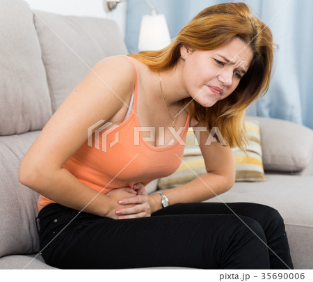 Portrait of ill female with pain in stomach Portrait of ill female with pain in stomach 35690006