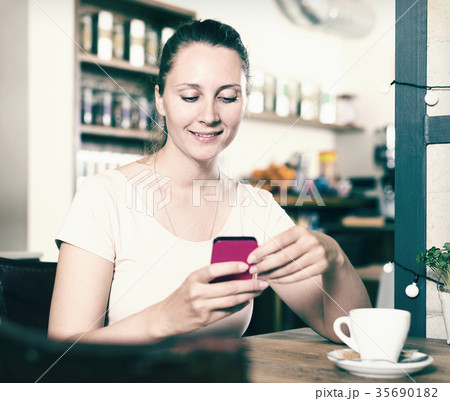 Girl ordered coffee and chatting in the phone Girl ordered coffee and chatting in the phone 35690182