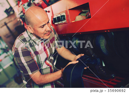 Professional diligent craftsman polishing footwear 35690692