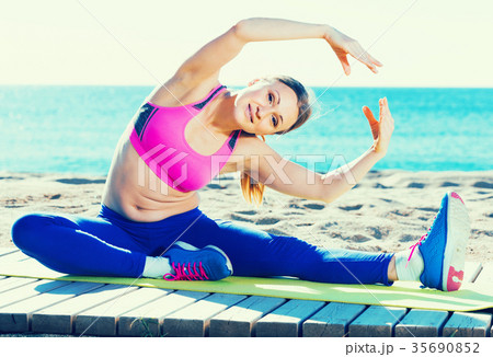 Beautiful female stretching muscles on the sand Beautiful female stretching muscles on the sand 35690852