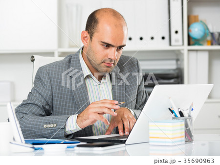 Businessman in office clothes filling up documents Businessman in office clothes filling up documents 35690963