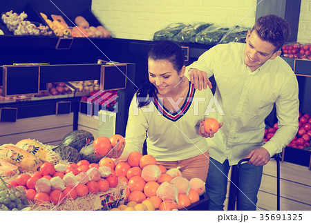 Couple choosing fruits in shop Couple choosing fruits in shop 35691325