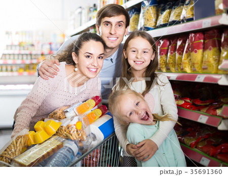 parents with two kids and purchases in shopping cart 35691360