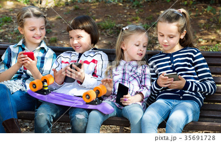 Group of children posing with mobile devices Group of children posing with mobile devices 35691728