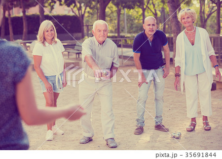 Mature people playing petanque together in park 35691844
