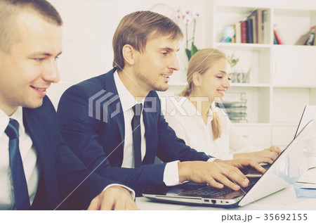 Cheerful business male sitting with coworkers 35692155