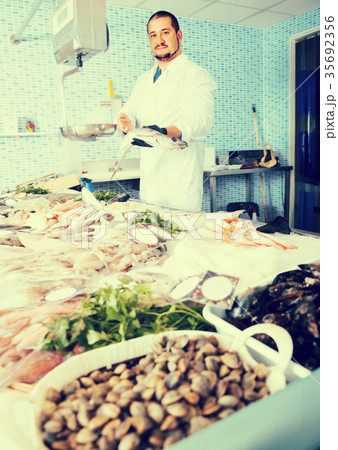 Seller holding fish 35692356