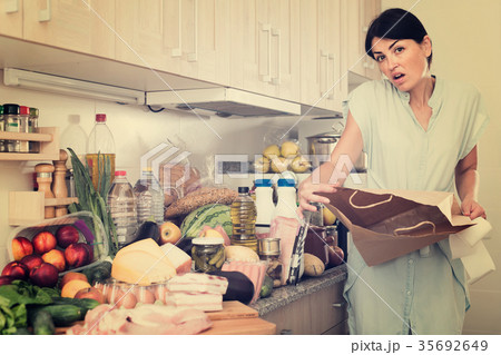 Woman is standing with paper bag and is sading because forgot to buy ingridient for recipe at home. Woman is standing with paper bag and is sading because forgot to buy ingridient for recipe at home. 35692649