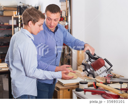 Woodworker working with pupil Woodworker working with pupil 35693101