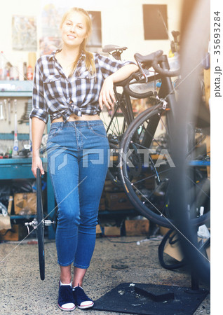 Smiling woman master is standing near bicycle Smiling woman master is standing near bicycle 35693284