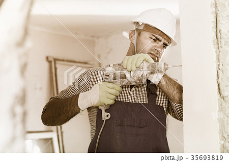 Adult male builder renovating with drill in gloves 35693819
