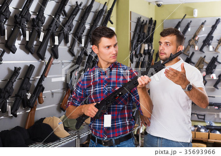 Friends choosing air-powered gun Friends choosing air-powered gun 35693966