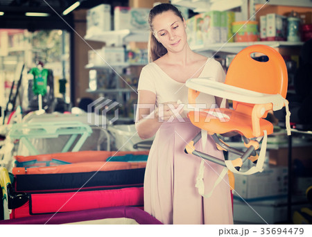 Pregnant woman choosing baby chair 35694479