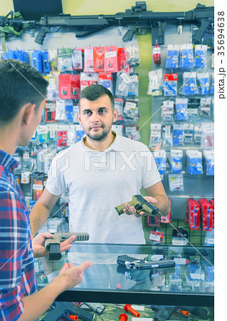 guy haelping customer to choose handgun in army market guy haelping customer to choose handgun in army market 35694638