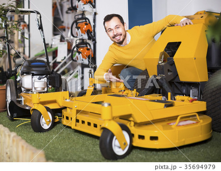 Man shows a large and powerful mulching mowers Man shows a large and powerful mulching mowers 35694979