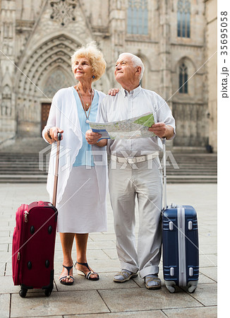 Senior woman and man traveling together looking for destination with city map Senior woman and man traveling together looking for destination with city map 35695058