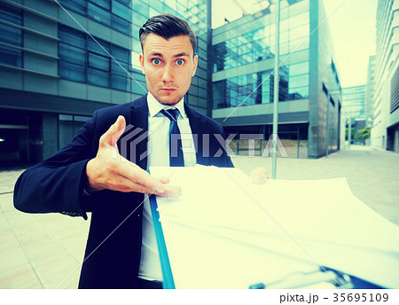 Office worker in suit is standing upset near office Office worker in suit is standing upset near office 35695109