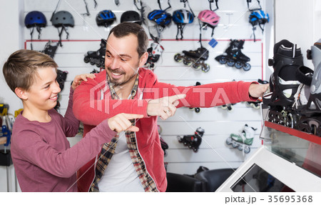 Father buying roller-skates for his son 35695368