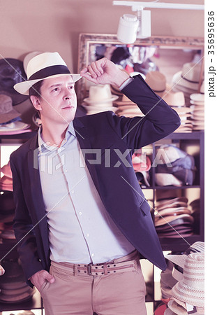 portrait of young guy try on panama at headwear store portrait of young guy try on panama at headwear store 35695636