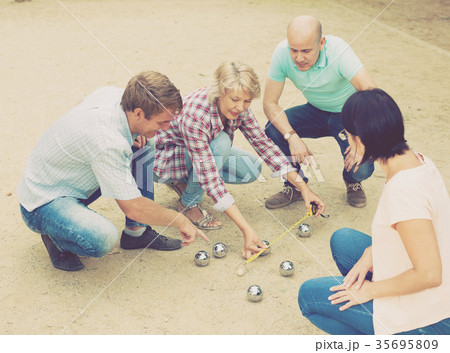 Smiling mature people playing petanque Smiling mature people playing petanque 35695809