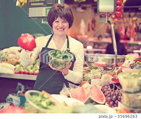 Middle aged woman selling fruits and vegetables 35696263