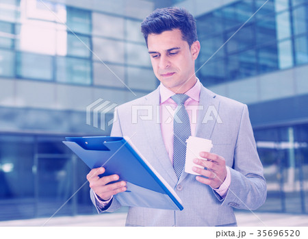 Serious manager reading papers Serious manager reading papers 35696520