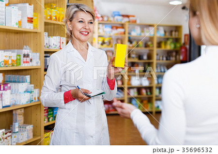 Mature female seller suggesting care products to young customer 35696532